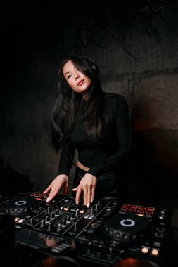 Kız DJ bir gece kulübünde müzik çalıyor. Kulüp eğlencesi, DJ konsolu
