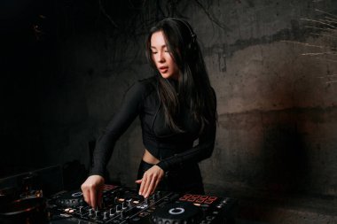 Kız DJ bir gece kulübünde müzik çalıyor. Kulüp eğlencesi, DJ konsolu