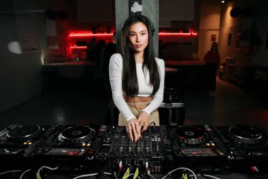 Kız DJ bir gece kulübünde müzik çalıyor. Kulüp eğlencesi, DJ konsolu