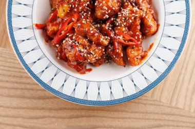 Lezzetli bir yemek güzel tasarlanmış bir kasede sunulur. Yemek, çeşitli mutfak geleneklerini temsil eden üzerine susam tohumları serpiştirilmiş renkli malzemeler içeriyor..