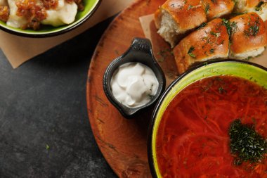 Yumuşak ekmek ve ekşi krema ile servis edilen bir kasede servis edilen Ukrayna yemeğinin tadını çıkarın. Sahne, gelenek ve lezzetin özünü yakalar..