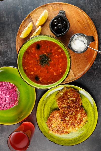 Tabaklar iki tabak ve bir kase üzerinde servis edilen Ukrayna ve Japon mutfağının bir karışımını temsil eder. Yanlarında siyah zeytin, limon dilimleri ve yakınlarda bir içecek var..