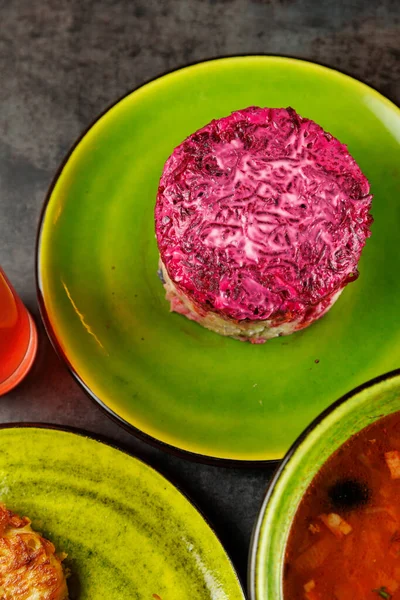 Ukrayna ve Japon mutfağından çeşitli yemekler parlak yeşil ve sarı tabaklarda sunulmaktadır. Her yemek, dinamik bir yemek ortamında eşsiz bileşenleri ve yemek stillerini ön plana çıkarır..