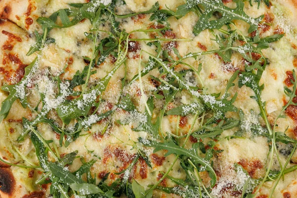 Taze bir pizza roka ve peynirle kaplanır ve mükemmel lezzet karışımı sergilenir. Akşam yemeği saatinde kalabalık bir pizzacıda bu yemeğin tadını çıkarırlar..