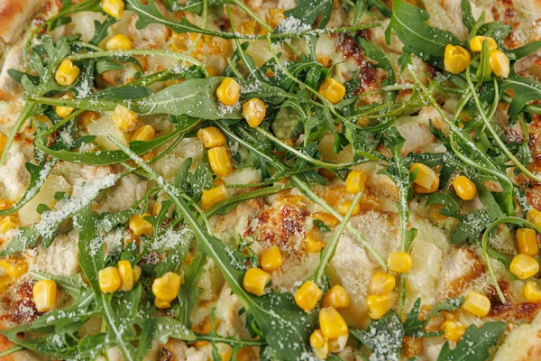 Peynir, mısır, roka ve diğer taze malzemelerle kaplı yassı ekmek arkadaşlarınızla veya ailenizle paylaşmak için renkli ve iştah açıcı bir yemek oluşturur..