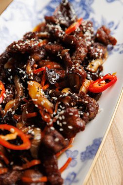 Taze suşi ruloları bambu yapraklı ahşap bir tabakta oturur..