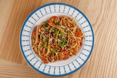 Farklı mutfaklardan yemekler sergileniyor, çeşitli malzemeler ve tatlar sergileniyor. Kase ahşap bir masada oturur ve yemek meraklılarını eşsiz yemekleri tatmaya davet eder..