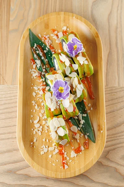 Tabaklarda taze sebzeler ve ahşap bir tabakta sıralanmış şifalı otlar var. Renkli malzemeler ve süslemeler çeşitli mutfaklar için cazip bir sunum oluşturur.