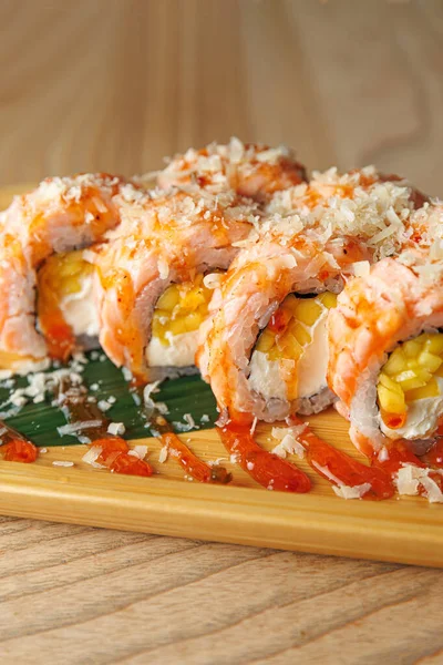 Karides ve yumurta dolu suşi ruloları tahta bir tabakta oturur. Tabakta gevşek bir yemek atmosferinde tadını çıkarmaya hazır deniz mahsulleri ve sos yer alıyor..