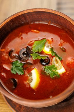 İçinde dilimlenmiş limonlar, siyah zeytinler ve taze otlarla dolu kırmızı pancar çorbası bulunan bir kase çorbanın tadını çıkarın. Bu yemek Ukrayna mutfağının mirası ve lezzetlerini sergiliyor.