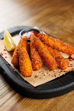 Kızarmış çubuklar ahşap tepside bir dilim limon ve sos ile düzenlenir. Bu yemek sıradan bir yemek ortamında, arkadaşlarla paylaşmak için mükemmel..