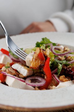 Bir lokanta, içinde tavuk, kırmızı biber, soğan ve ceviz bulunan ve Ukrayna ve Japon mutfak stillerinin bir karışımını sergileyen karışık salatadan hoşlanır..