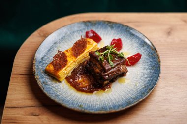 Bir tabakta fırında hamur işi ve jöle parçalarının yanında soslu yumuşak sığır eti sergileniyor. Ayarlar, Ukrayna ve Japon mutfağının özel bir yemek için mükemmel bir karışım olduğunu gösteriyor..