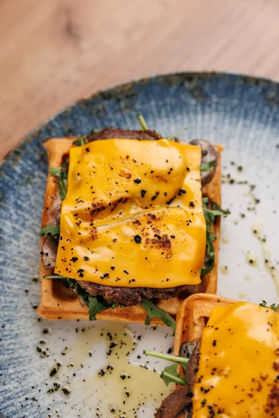 Ağız sulandıran waffle sandviçi eritilmiş peynir, taze yeşillikler ve baharatlar içerir. Bu yemek her yemek için mükemmel bir lezzet karışımı sunar. Lezzetli kombinasyonun tadını çıkar.