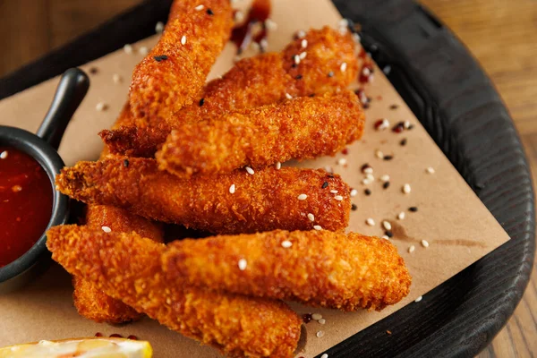 Bir tabak yanında küçük bir kase sosla birlikte düzgünce düzenlenmiş birkaç kızarmış atıştırmalık tutar. Bu yemek bir toplantıda paylaşmak için mükemmel..