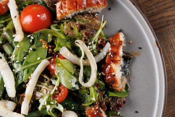 Tabakta taze sebze, ızgara balık ve vişneli domates karışımı. Çanak farklı kültürlerden elementleri renkli bir sunumla sergiliyor..