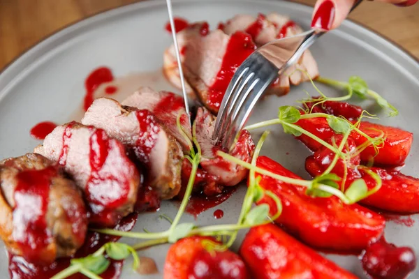 Dilimler zengin bir sos ve tabakta taze çilek ile servis edilir. Bir çatal ve bıçak eti kesmek için kullanılır. Gündelik yemek için uygun bir ortam..