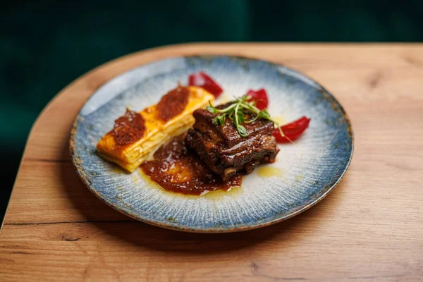 Bir tabak lezzetli Ukrayna ve Japon yemekleri içerir, yumuşak pirzola, tuzlu sos ve yanında kremalı bir tabak. Yemek sıcak bir yemek ortamında sergileniyor..