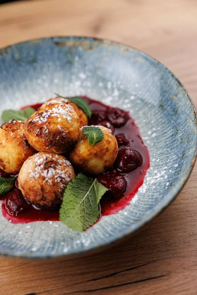 Hamur köfteleri canlı böğürtlen soslu ve taze nane yapraklarıyla süslenmiş bir kasede düzenlenir. Yemeklerde Ukrayna mutfağının geleneksel tatları sergileniyor.