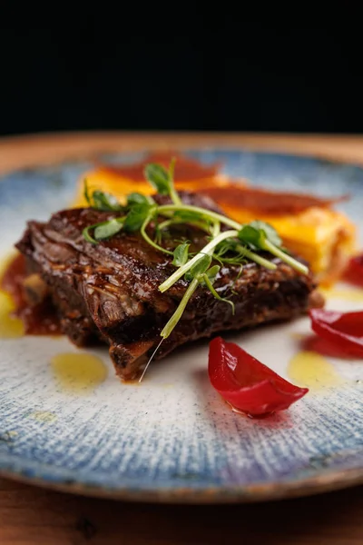 Zengin bir tabakta, çok kültürlü bir yemek deneyiminde lezzetlerin karışımını vurgulayan süslü ve renkli kenarlı yumuşak sığır eti yer..