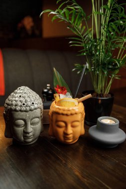 Buda 'ya benzeyen iki eşsiz kupa ve bir keşiş içkilerle doludur. Bir bitki ve bir mum restoranın sıcak atmosferine eklenir..