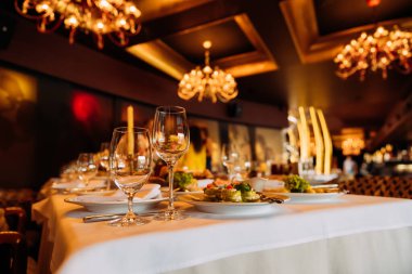 Yemek masasında çeşitli mutfaklardan çeşitli tabaklar sunulmaktadır. Zarif cam eşyalar şık bir restoranda misafirler için hazır..