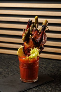 Tavuk kanatları turşu ve limonlu şişler üzerine dizilir, bardakta sunulur. Bu yemek çeşitli mutfaklardan gelen lezzet ve dokuların birleşiminin altını çiziyor..