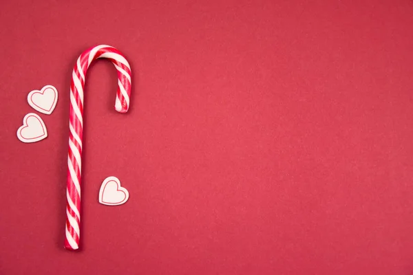 Candy Cane with hearts top view frame red background stock images. Christmas candy cane border stock images. Candy cane isolated on a red background with copy space for text