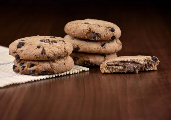 Pile of chocolate chip cookies on a wooden background stock images. Sweet chocolate cookies on the table images. American sweet biscuits photo. Cookies on a wooden background with copy space for text