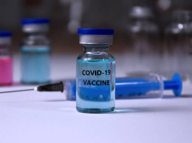 Ampuller COVID-19 aşısı laboratuvar arkaplan görüntüleri üzerinde. Şırınga ve cam laboratuvar malzemeleriyle yapılmış Covid 19 aşısı. Laboratuvar aksesuarları stok fotoğrafı