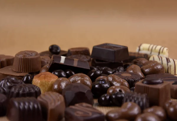 背景の茶色のフレームストック画像上の様々なチョコレートのプラリネ ダークチョコレートとミルクチョコレートキャンディーのクローズアップストックフォト テキストのためのコピースペースと茶色の背景に豪華なベルギーのチョコレートのプラリネ — ストック写真