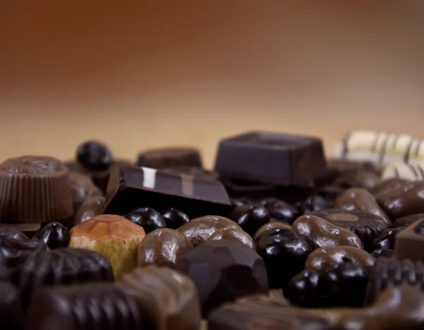 背景の茶色のフレームストック画像上の様々なチョコレートのプラリネ ダークチョコレートとミルクチョコレートキャンディーのクローズアップストックフォト テキストのためのコピースペースと茶色の背景に豪華なベルギーのチョコレートのプラリネ — ストック写真