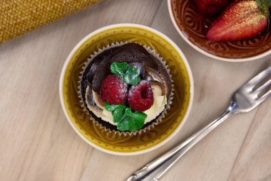 Üzerinde ahududu resmi olan çikolatalı vanilyalı kek. Lezzetli kremalı kek ve masanın üstünde böğürtlen resmi. Böğürtlenli taze kek.