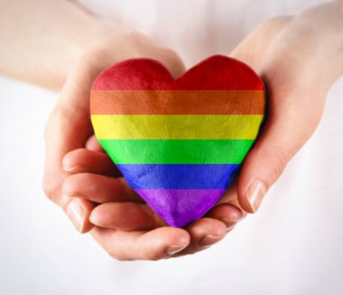 Kadınların elindeki gökkuşağı LGBT kalbi görüntü depoluyor. Kadın elleri gökkuşağı kalbi resmi veriyor. Kalp şeklindeki gökkuşağı gurur bayrağı. LGBT gökkuşağı kalp aşk sembolü
