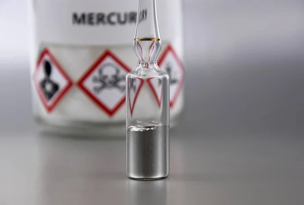 Civa kimyasal element stok görüntüleri. Laboratuvar aksesuarları görüntüleri. Mühürlü ampule sahip bir fotoğraftaki cıva. Gümüş arka planda laboratuvar ekipmanları. Hg, zehirli kimyasal element stok görüntüleri