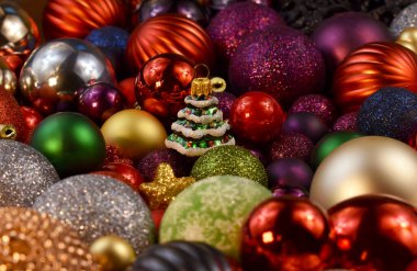 Yılbaşı arkaplanında bir sürü renkli mücevher ve yakın plan fotoğraf resimleri var. Bir sürü renkli, parlak Noel süsleri arka plan fotoğrafı. Arkaplan, afiş, kart için şablon