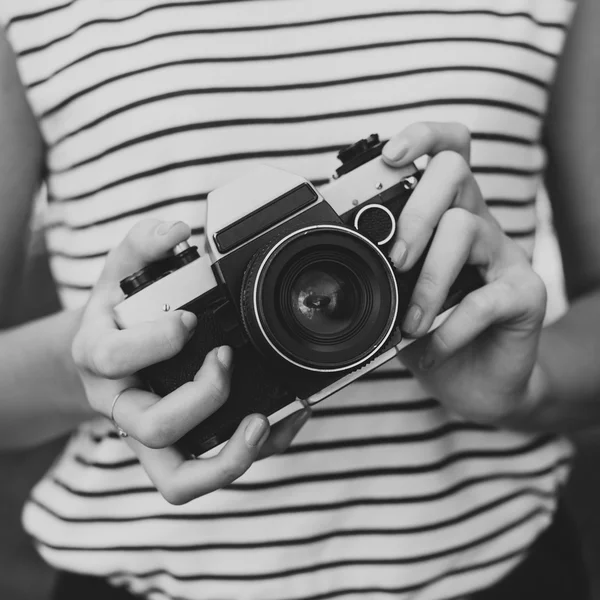 Photo camera in the hands of the girl — Stock Photo, Image