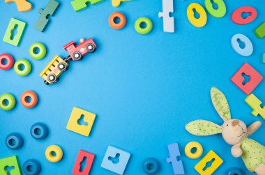 Çocukların dünyası mavi arka plandaki küçük çocuklar için ışık kutusunda ve oyuncaklarla mesajlaşıyor. Düz yatıyordu. Renkli ahşap oyuncaklar, tavşan ve tren..