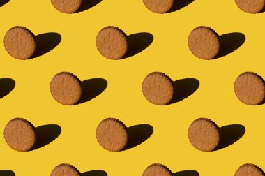 Sarı arka planda kurabiye deseni. Asgari trend güneş ışığı konsepti