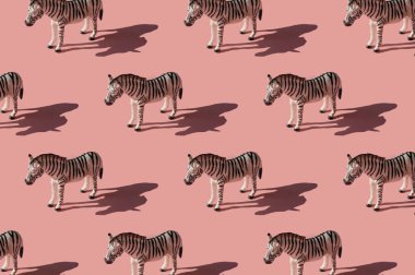 Pembe arka planda zebra oyuncağıyla yapılmış. Sert güneş ışığı gölgeli modaya uygun küçük resim.