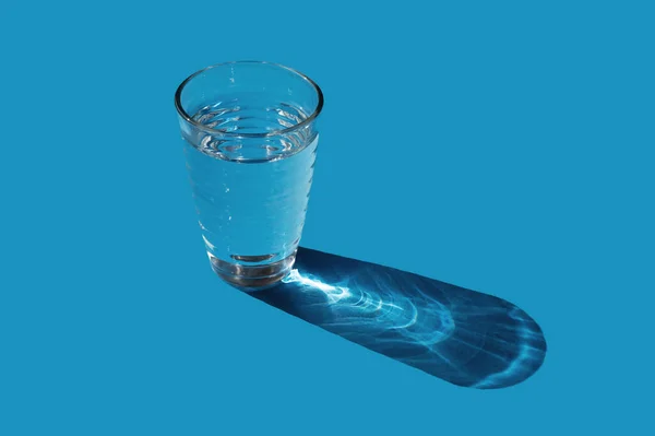 Copo Água Sobre Fundo Azul Conceito Mínimo Luz Solar — Fotografia de Stock