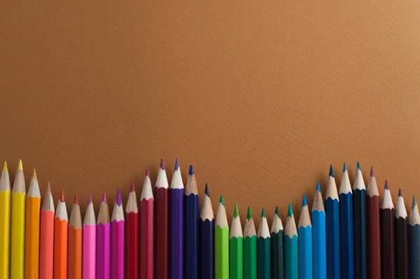 Lápices de colores sobre un fondo de mostaza . —  Fotos de Stock