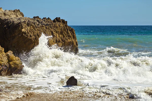 Vlny narážející do pobřežní skály na útesech — Stock fotografie