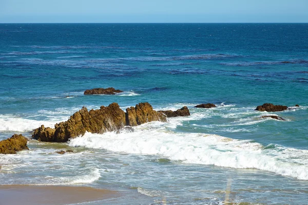 Golven gewonnen tegen kust rotsen op de rotsen — Stockfoto