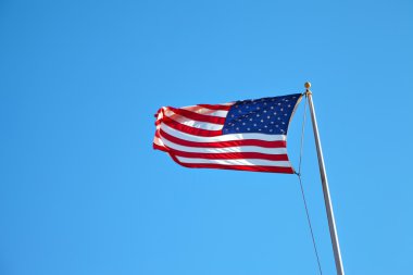 Mavi gökyüzünde dalgalanan Amerikan bayrağı