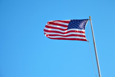 Mavi gökyüzünde dalgalanan Amerikan bayrağı