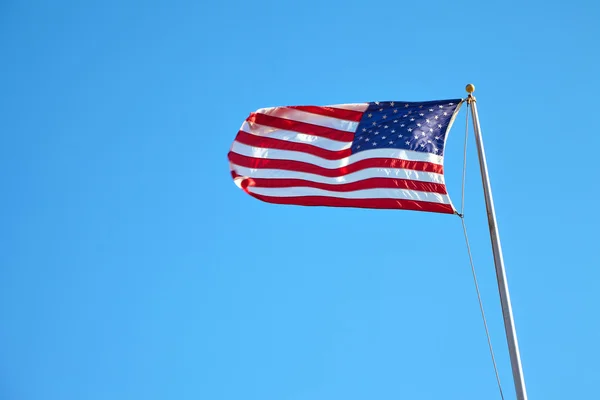 Mavi gökyüzünde dalgalanan Amerikan bayrağı