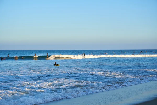 Malibu, California, USA - September 2016: Surfing people ride on the waves