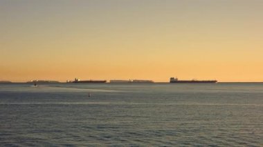 Kaliforniya 'da güneşli bir gün. Long Beach USA 'deki kargo limanının görüntüsü. Güneş, okyanusun huş ağacı suyunda parlıyor..