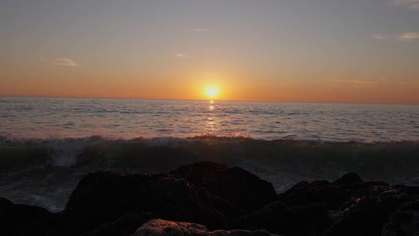 Drámai óceáni naplemente. Égő ég és ragyogó arany hullámok elérték a sziklákat. Naplemente tenger 4K. Repülnek a sirályok. Vörös ég, sárga nap és csodálatos tenger. Nyári naplemente. Lassú mozgás.. — Stock videók